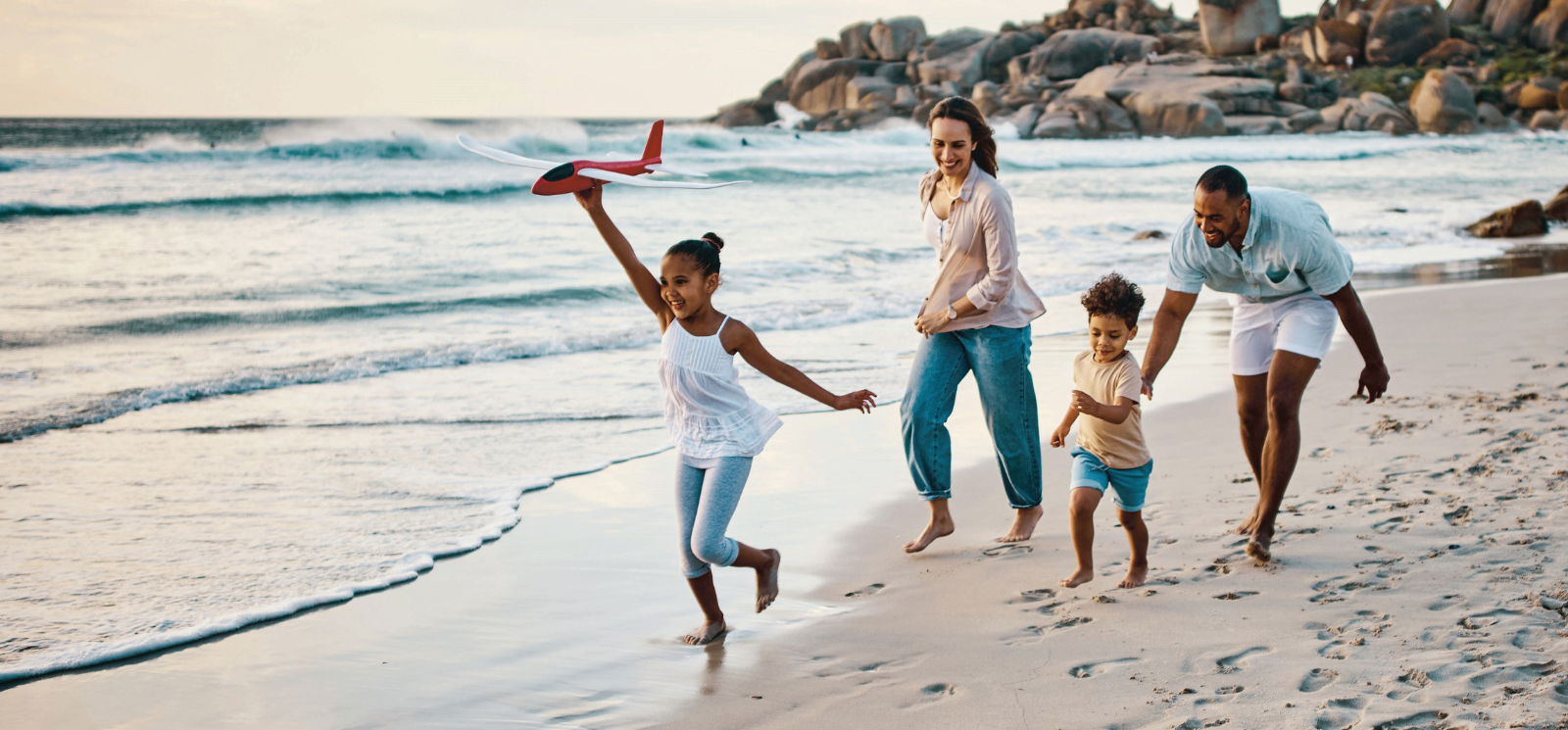 Family playing on the beach. Representing BankGloucester checking accounts. Elite Rewards Checking earns 4.06% APY*.