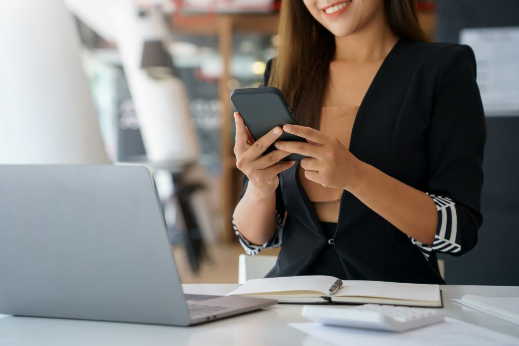 Woman on phone and in front of a computer. 